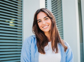 Woman with white teeth smiling while standing outside