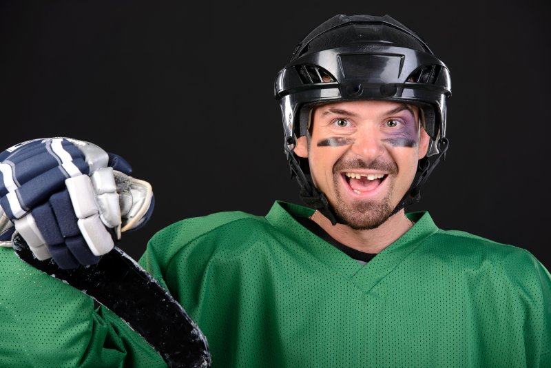 A smiling hockey player with a chipped or missing tooth